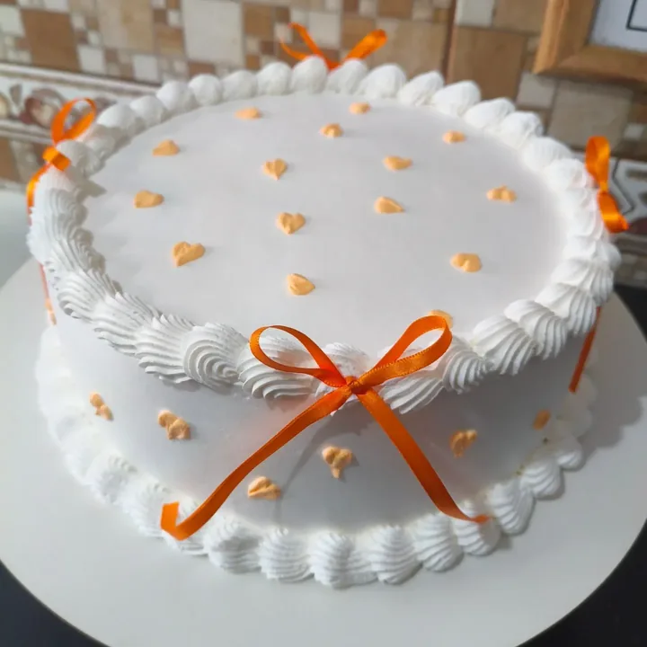 Bolo branco com laços laranja