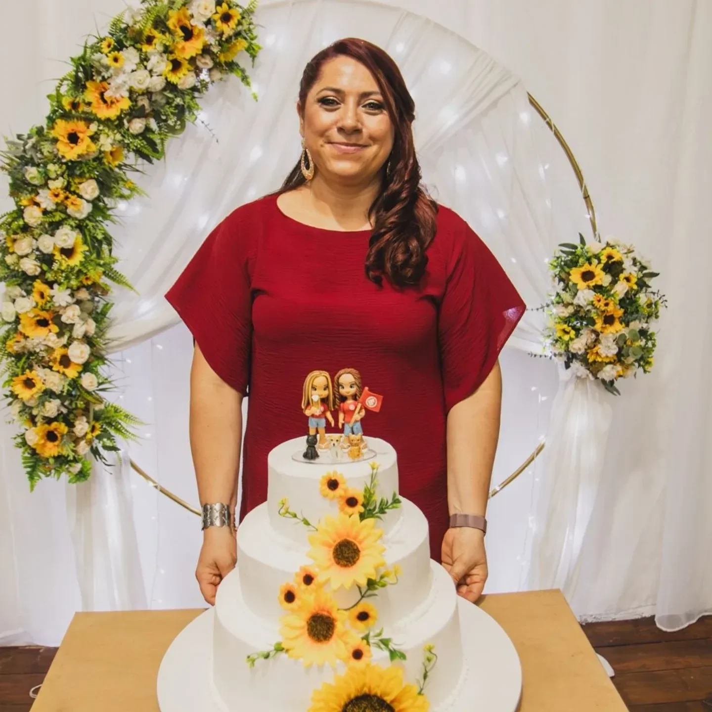 Confeiteira segurando bolo decorado com girassóis